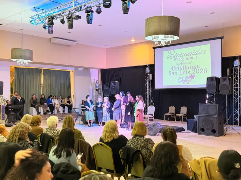 Presentación en un salón con público y luces de colores.
