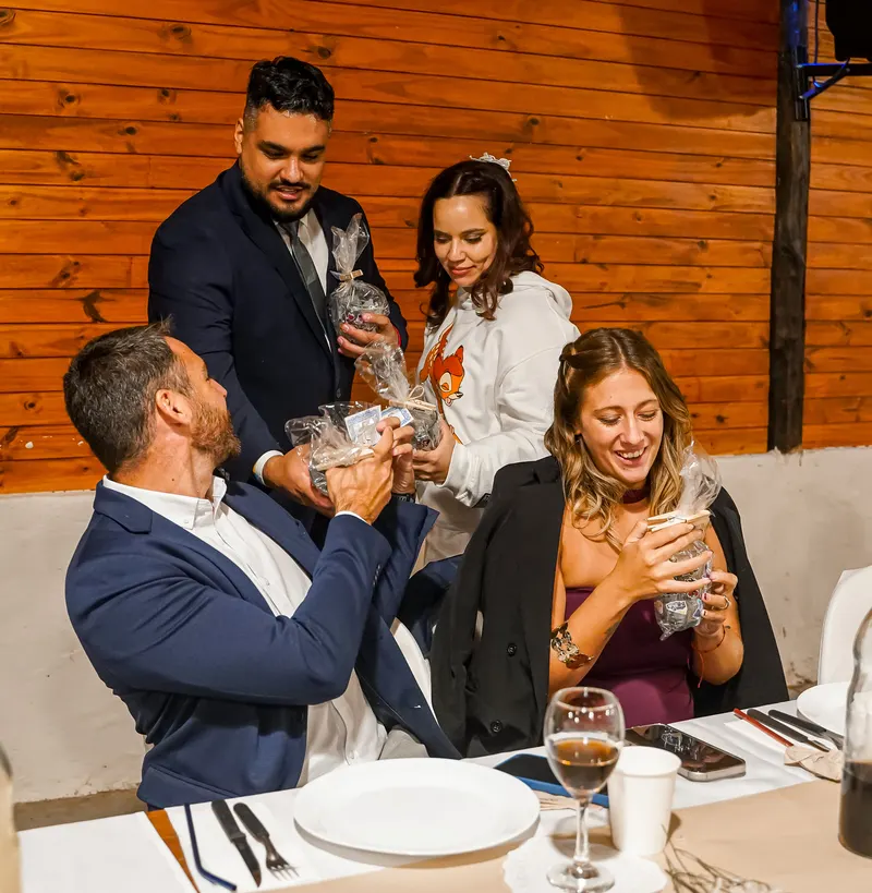 Invitados comparten un brindis alrededor de una mesa.